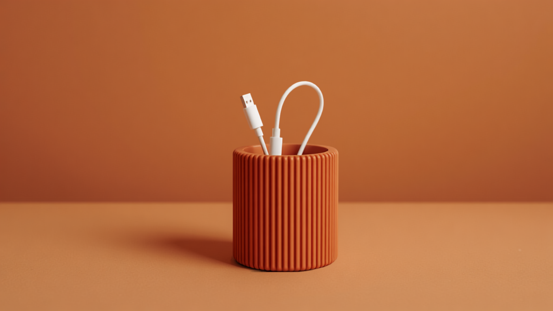 Organizador de cables QAYTU impreso en 3D con textura estriada terracota con cables USB